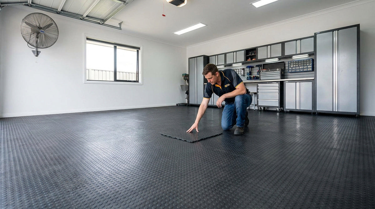Garage ou atelier automobile avec sol sombre en dalles texturées, un professionnel inspectant une dalle au sol