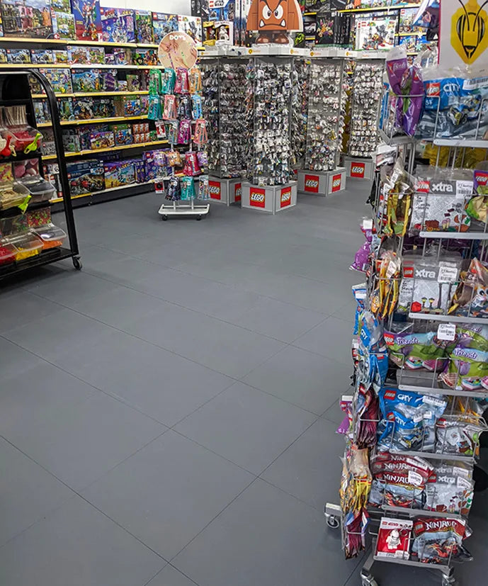 Rayon LEGO du magasin BEETOYS : sol uniforme en dalles ULTIMA JOINTS INVISIBLES gris foncé sous les présentoirs