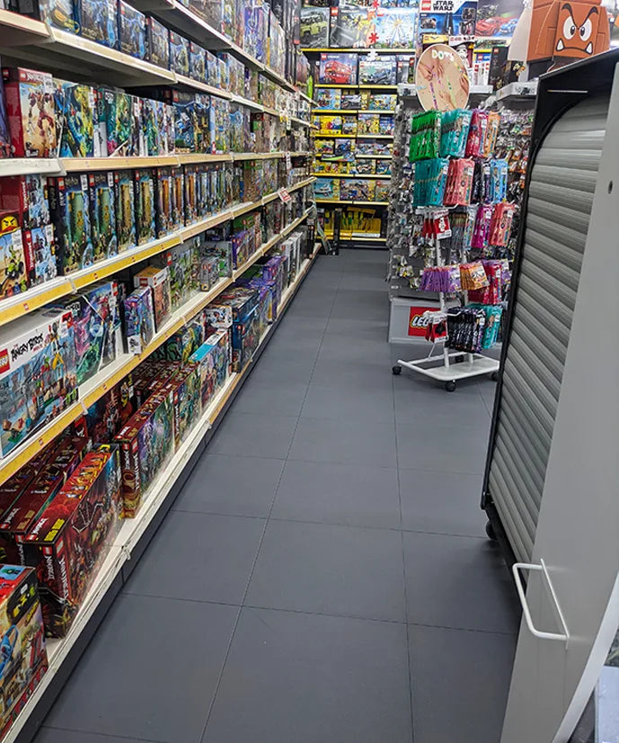 Allée de rayonnages BEETOYS avec armoire à rideau roulante sur dalles PVC clipsables gris foncé