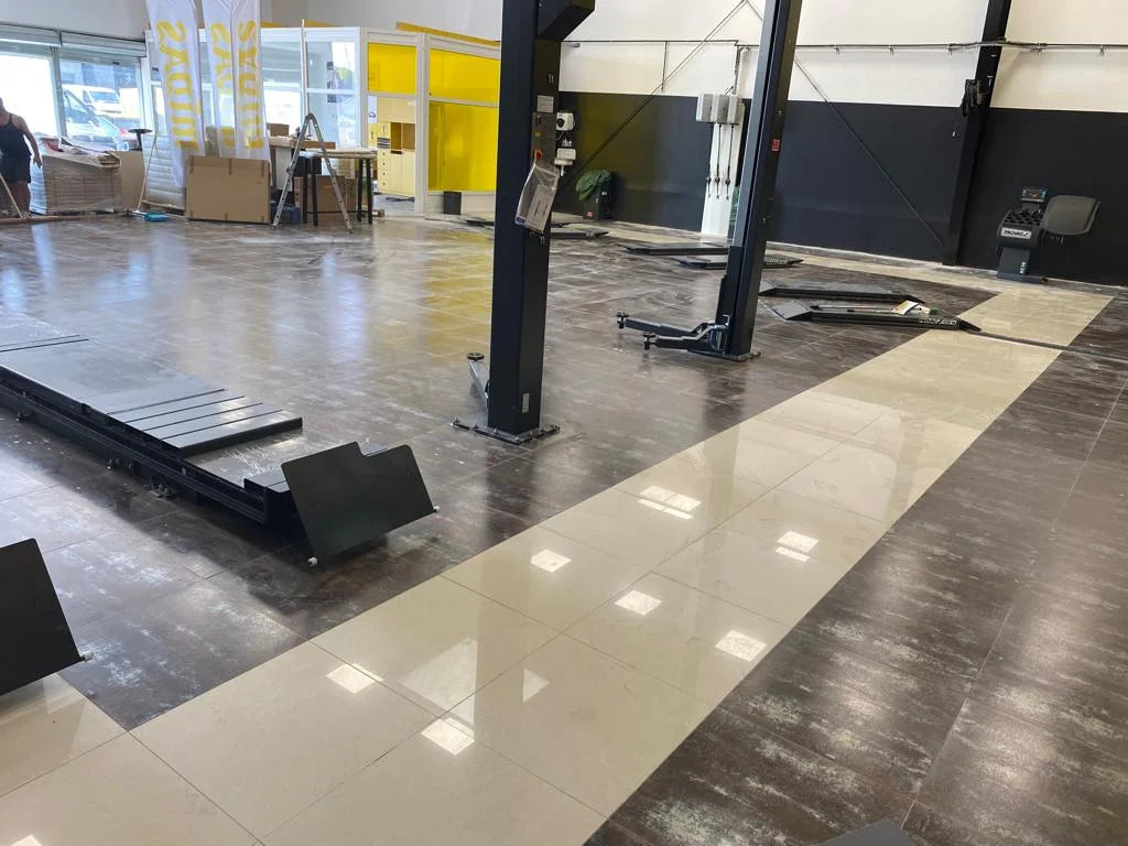 Before: Slippery tile flooring under the lift platforms at the Brie Auto Services auto center