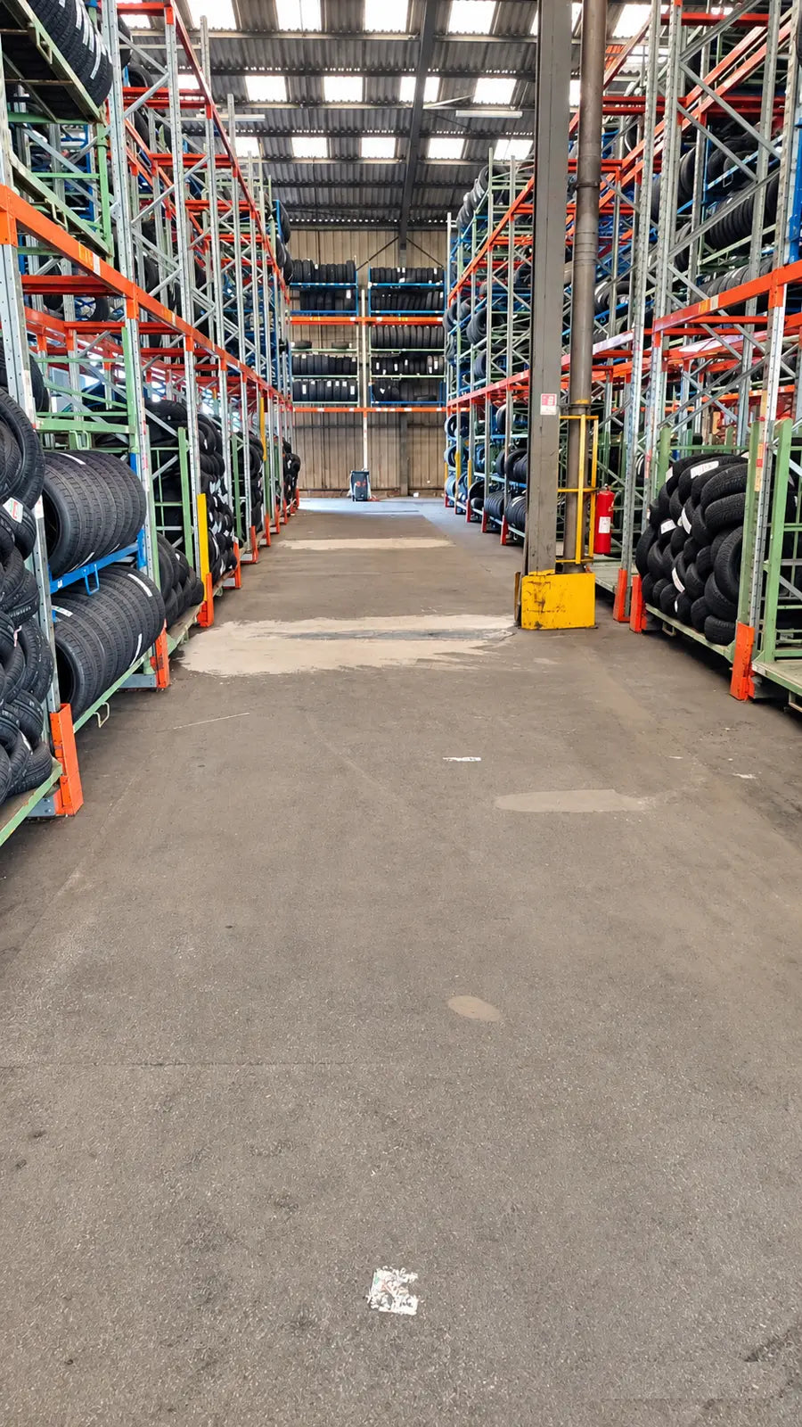 Avant : allée de racks sur béton endommagé, entrepôt Copadex