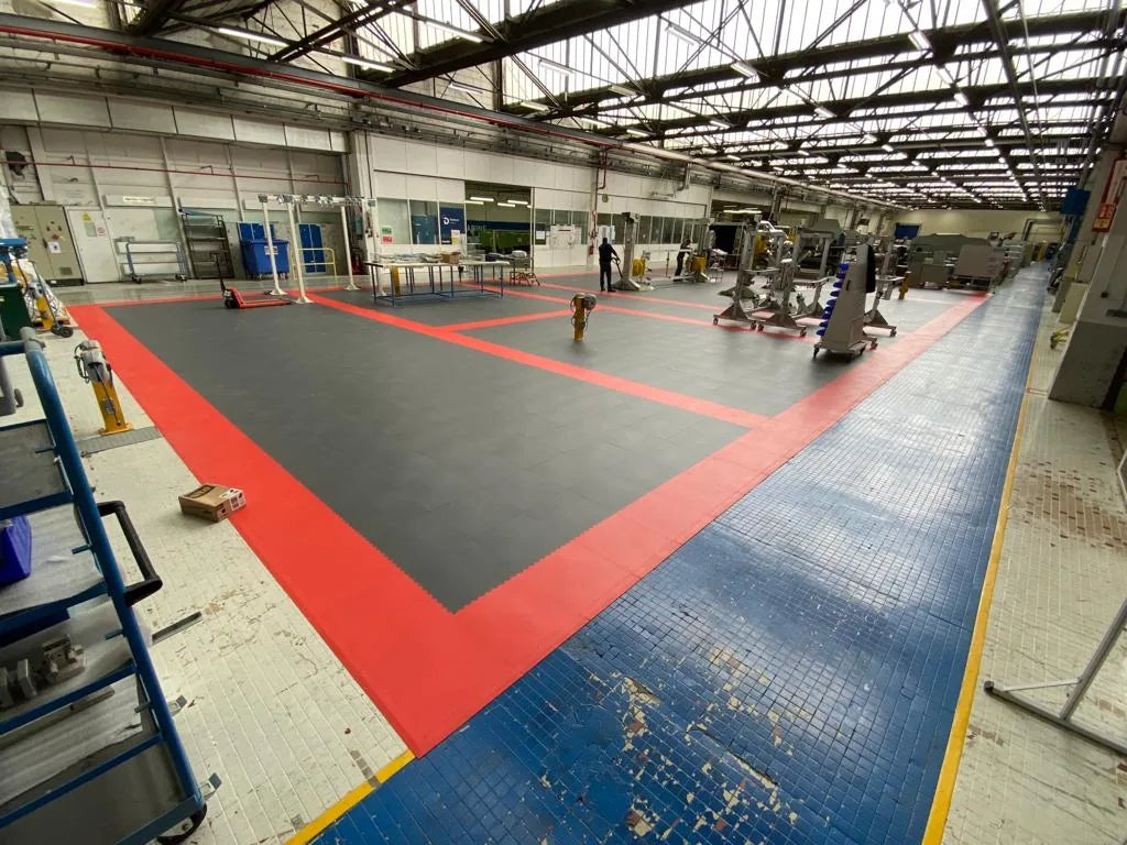 Hall DAHER après pose : dalles PVC ULTIMA INDUSTRY PURE gris foncé avec zonage rouge, chariots et postes de travail