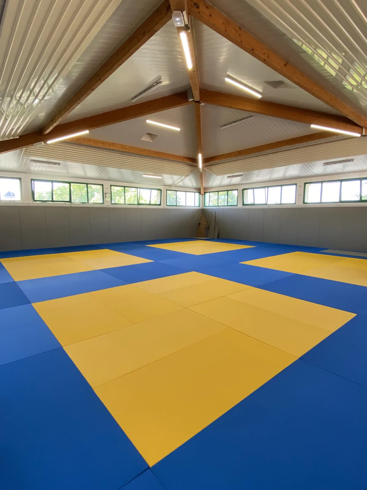 Dojo de Saint-Genis-les-Ollières après pose : 200 m² de tatamis antidérapants bleus et jaunes et protections murales grises