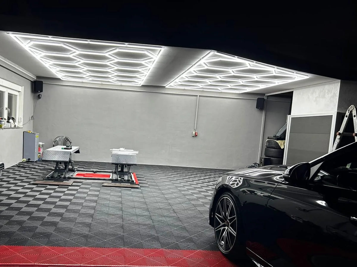 Atelier en dalles AERO petit damier noir et gris avec bande rouge, sous plafonniers LED hexagones