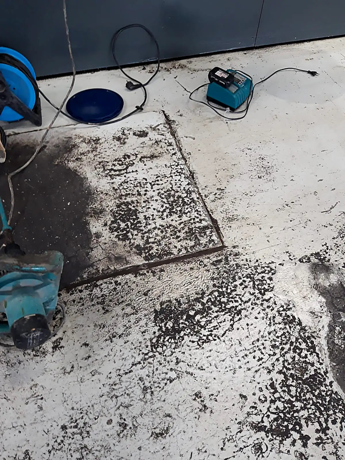 Avant : ancien revêtement écaillé et taché d'huile dans un garage professionnel