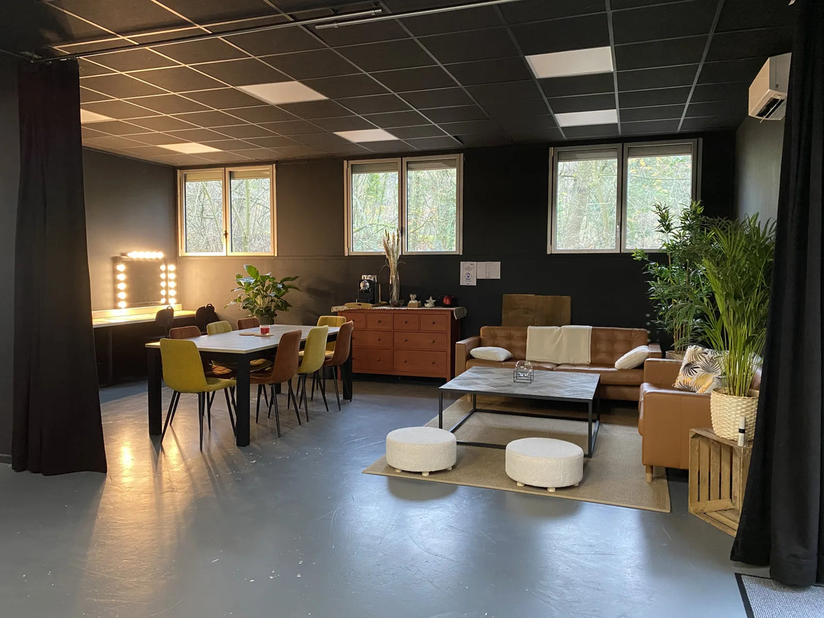 Studio Ici et Maintenant avant travaux : ancienne résine qui s'écaille, coin salon et table de réunion