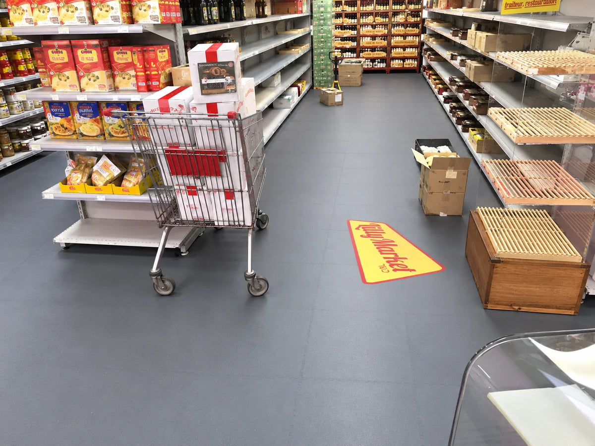 Allée du supermarché Lilly Market à Villeurbanne, dalles ULTIMA INDUSTRY gris foncé et logo imprimé au sol