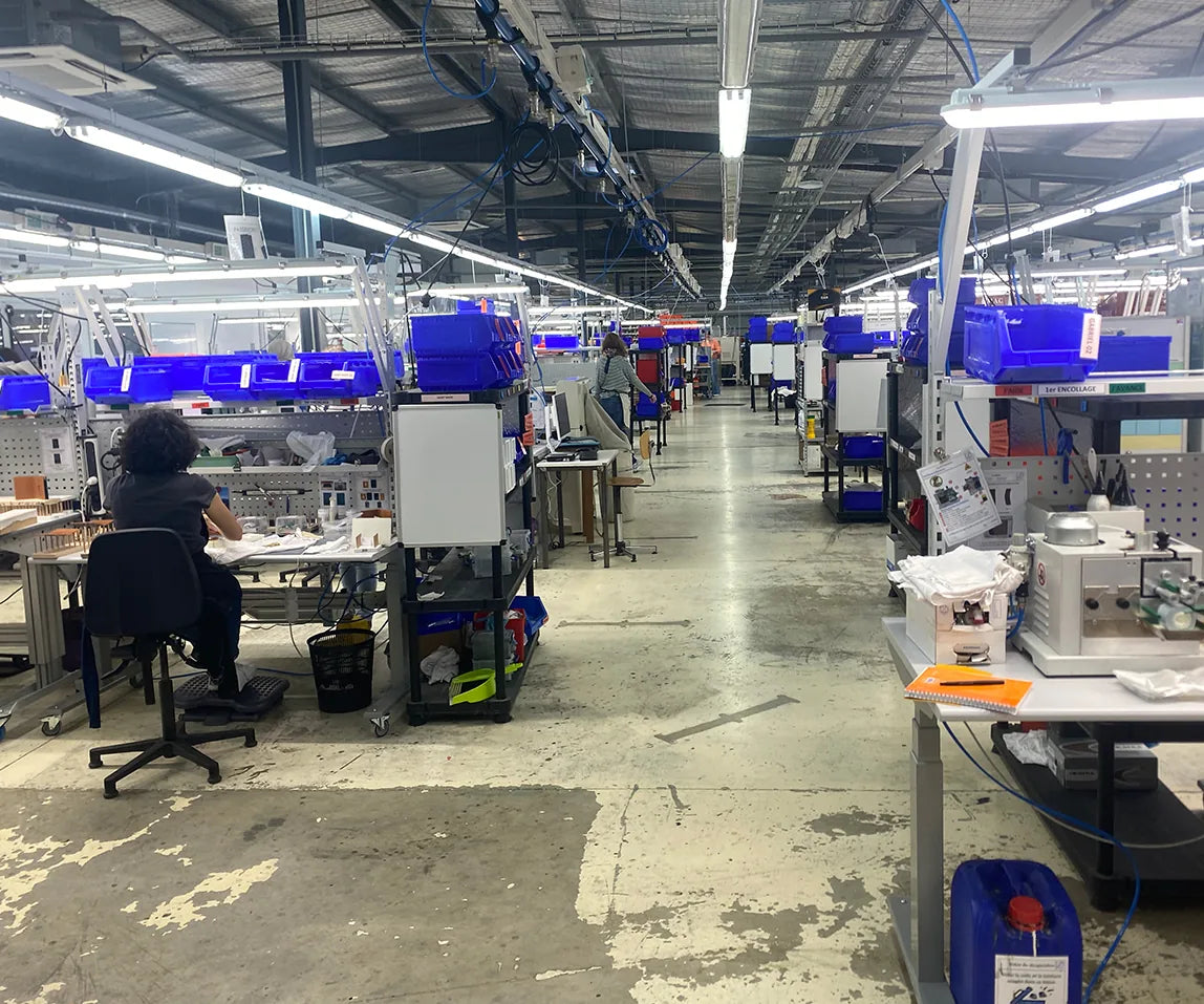 Atelier de maroquinerie avant travaux : béton vieillissant taché et écaillé entre les postes