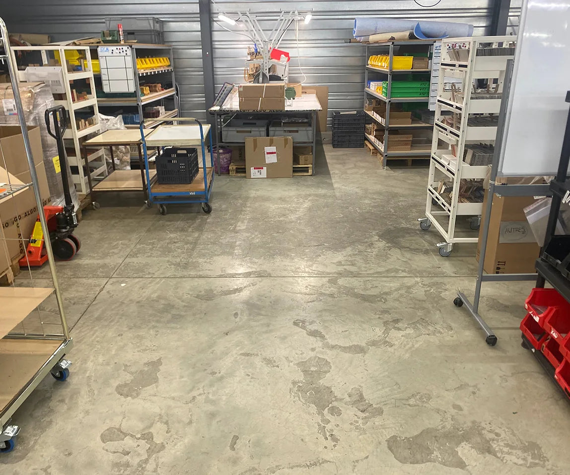 Zone de stockage de la maroquinerie avant travaux : béton brut taché