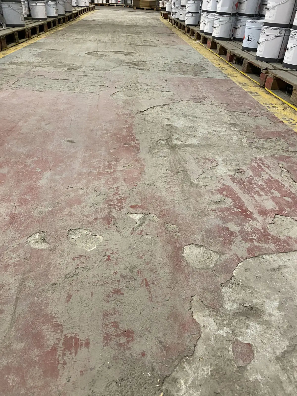 Poyet Motte avant travaux : sol d'entrepôt très endommagé, peinture et béton arrachés