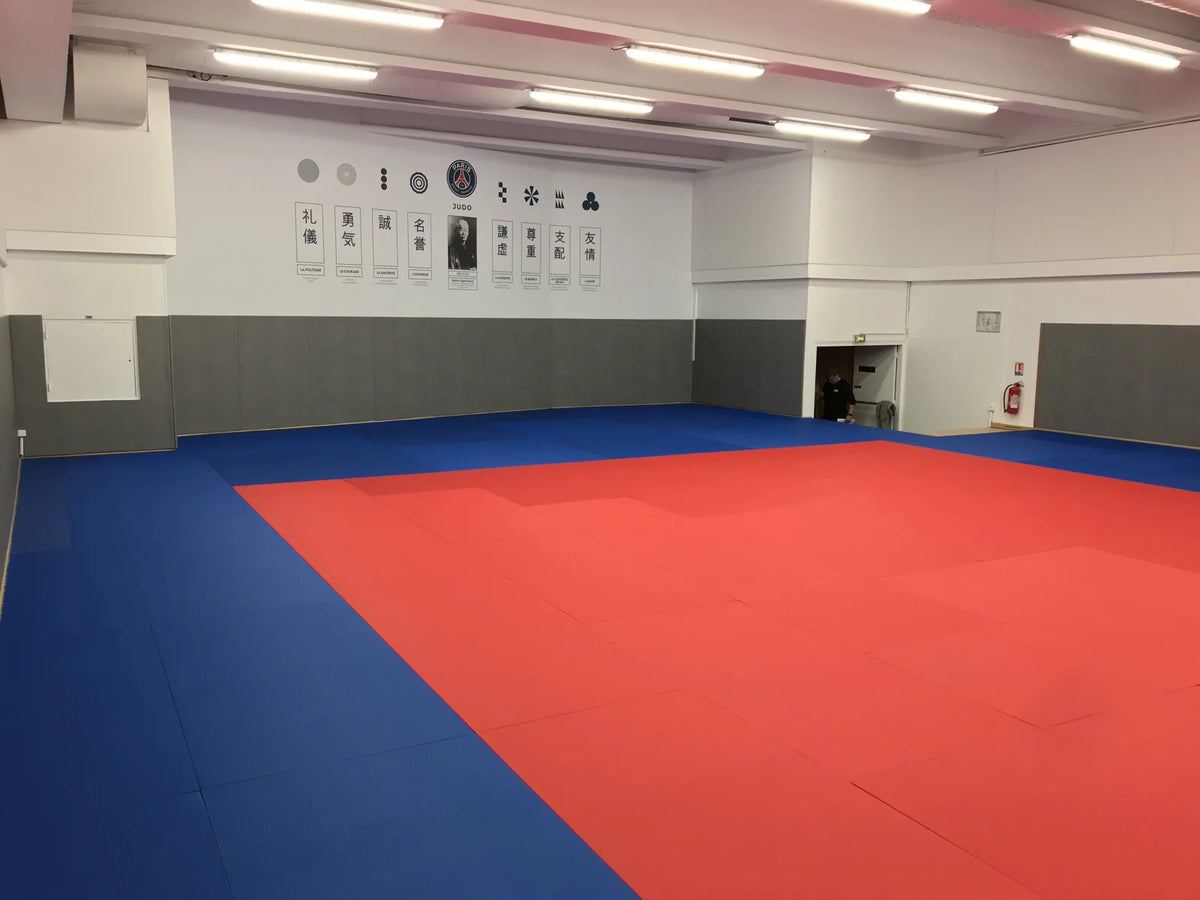 Tatamis bleu et rouge posés sur parquet au dojo du PSG Judo à Paris, 200 m² installés en une journée