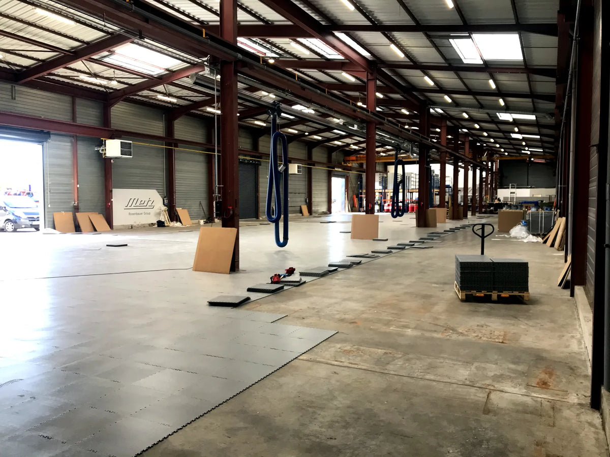 Rosenbauer: Installing light gray ULTIMA INDUSTRY tiles over the existing concrete floor in the workshop