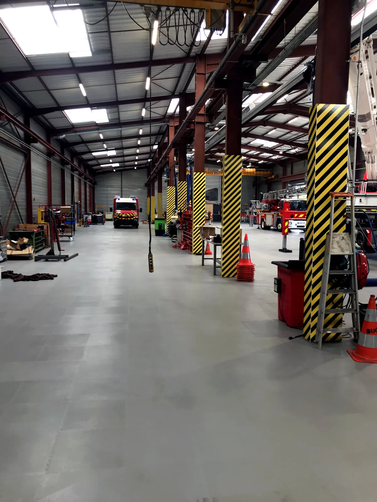 Rosenbauer Workshop: Pathway paved with light gray ULTIMA INDUSTRY slabs between the repair stations