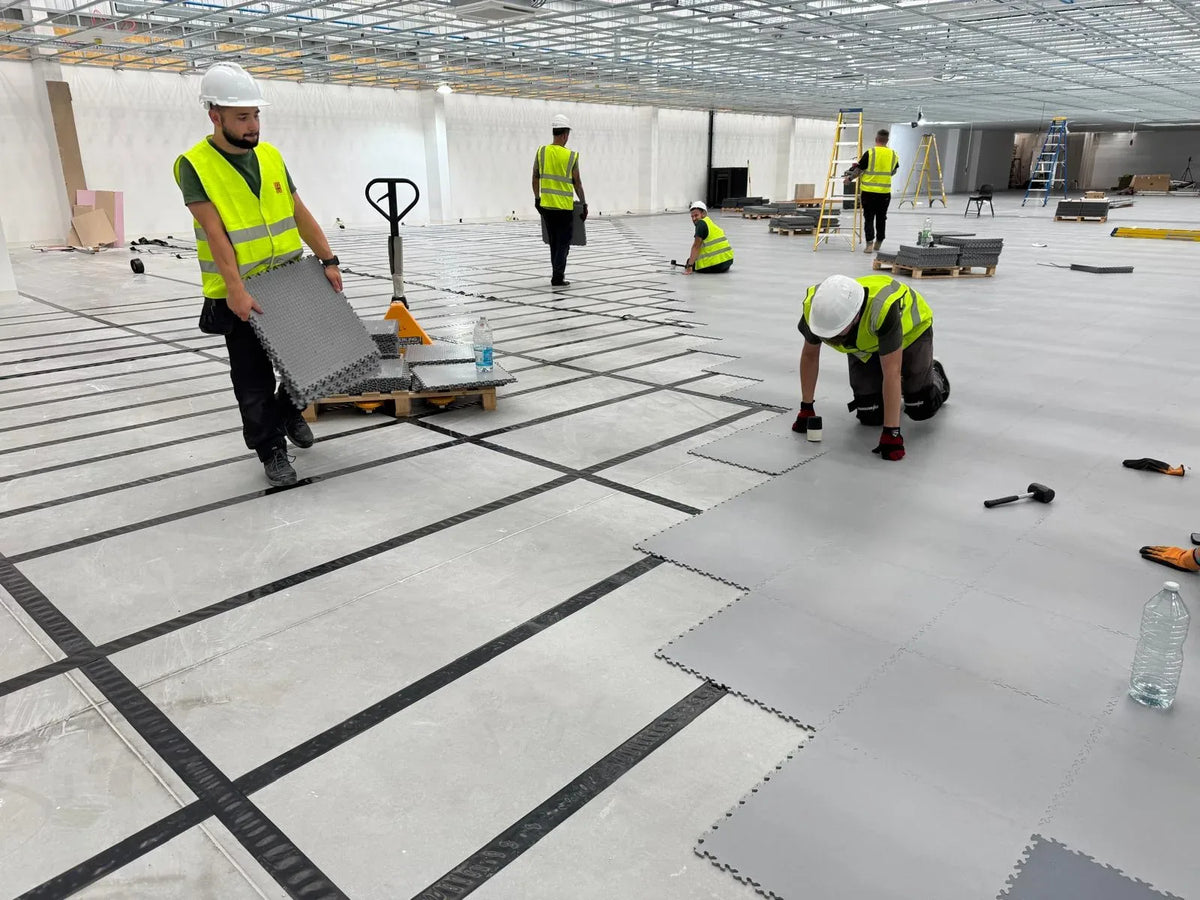 Pose des dalles PVC ESD gris clair sur quadrillage de ruban conducteur, Pays-Bas