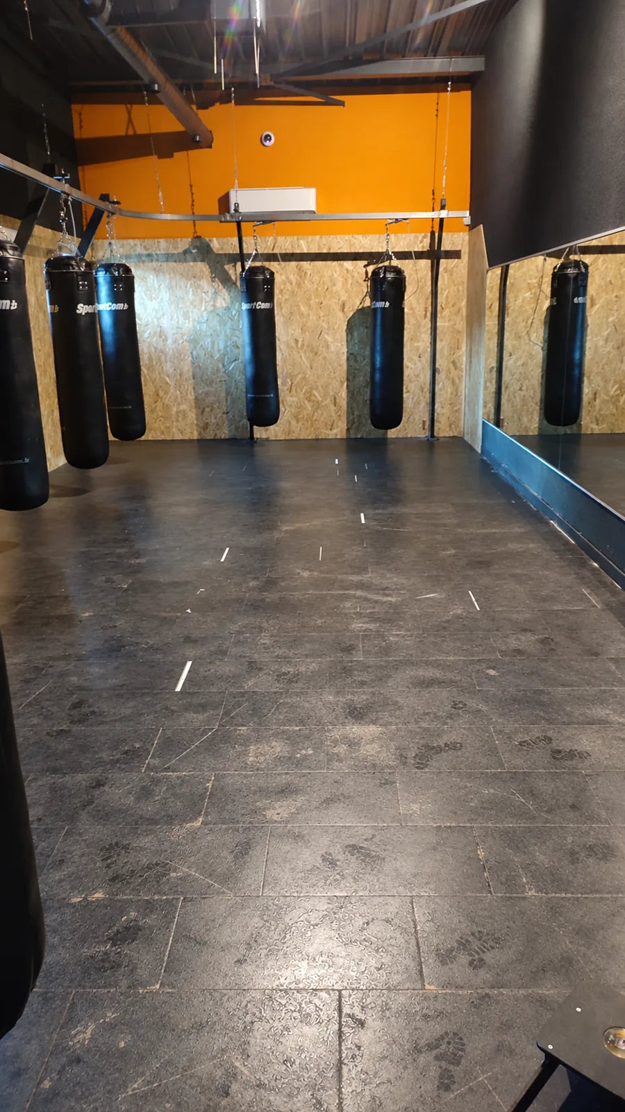 Ancien carrelage usé de l'espace boxe L'Appart Fitness avant la pose des dalles PVC