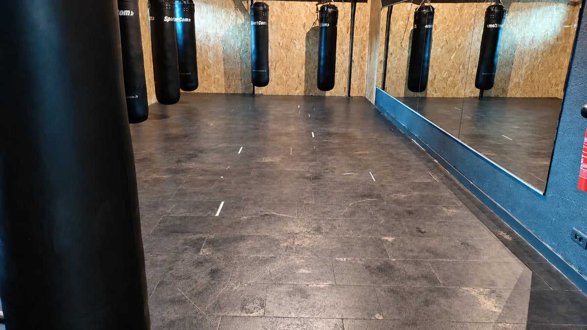 Espace boxe L'Appart Fitness avant travaux : ancien carrelage endommagé et taché