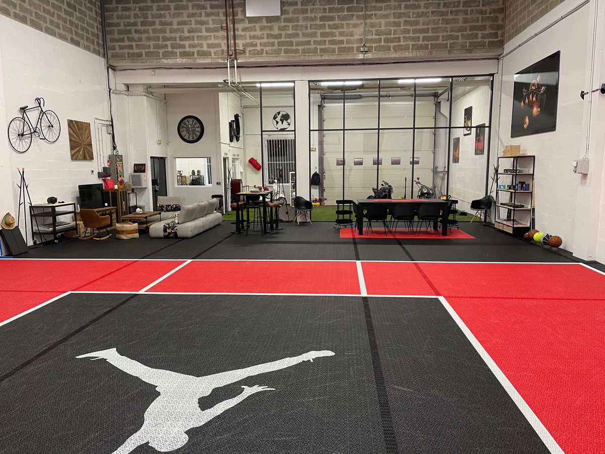 Logo imprimé sur les dalles BERGO ULTIMATE noires au centre du terrain de basket