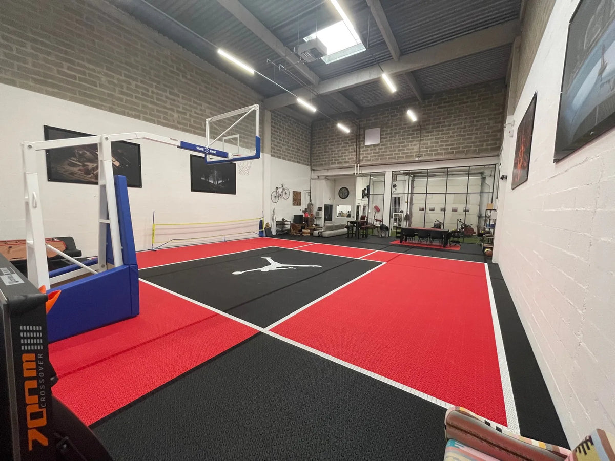 Terrain de basket intérieur en dalles BERGO ULTIMATE rouge et noir, lignes blanches intégrées