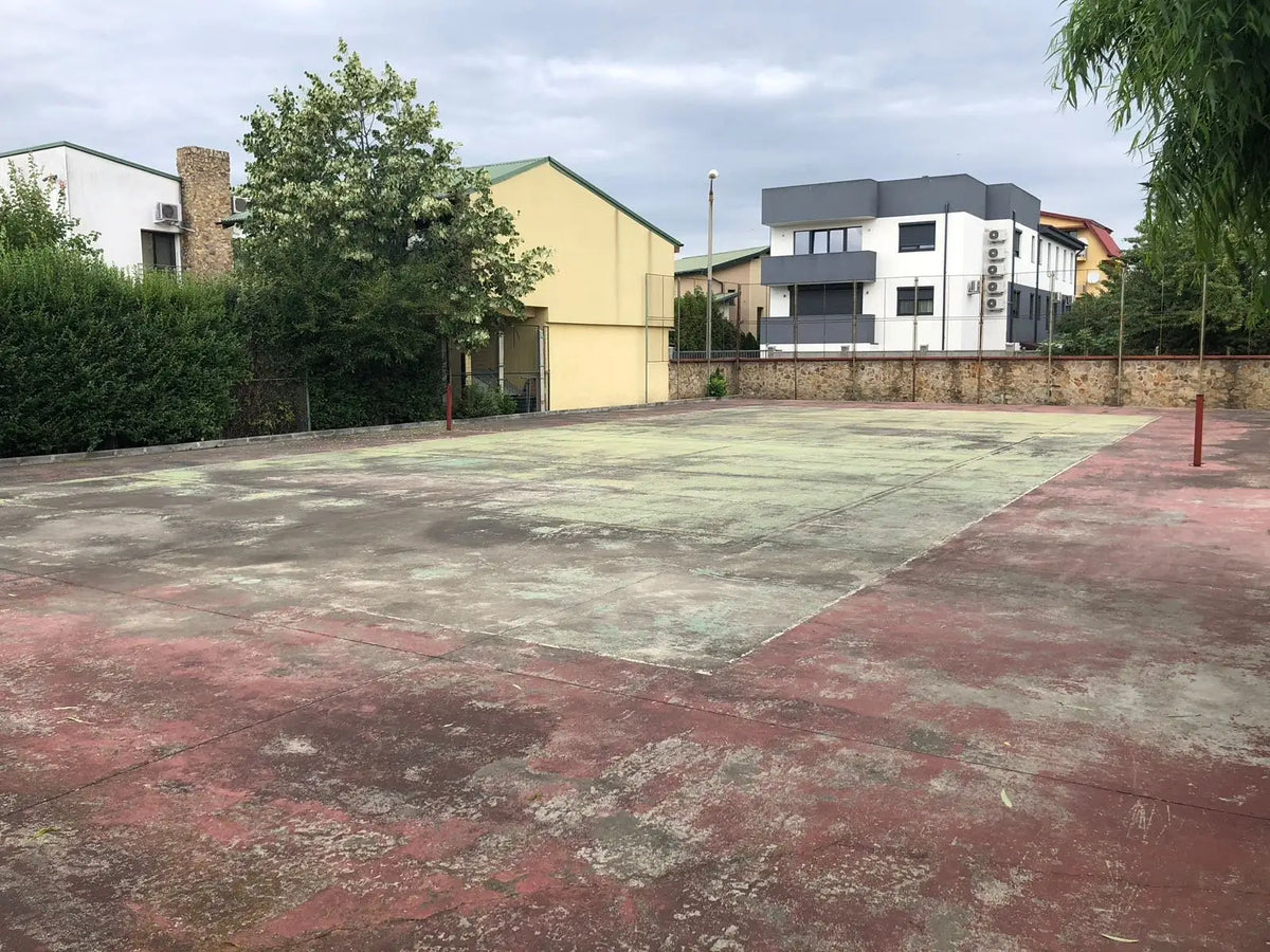 Terrain de tennis avant rénovation : ancien revêtement délavé, taché, lignes effacées