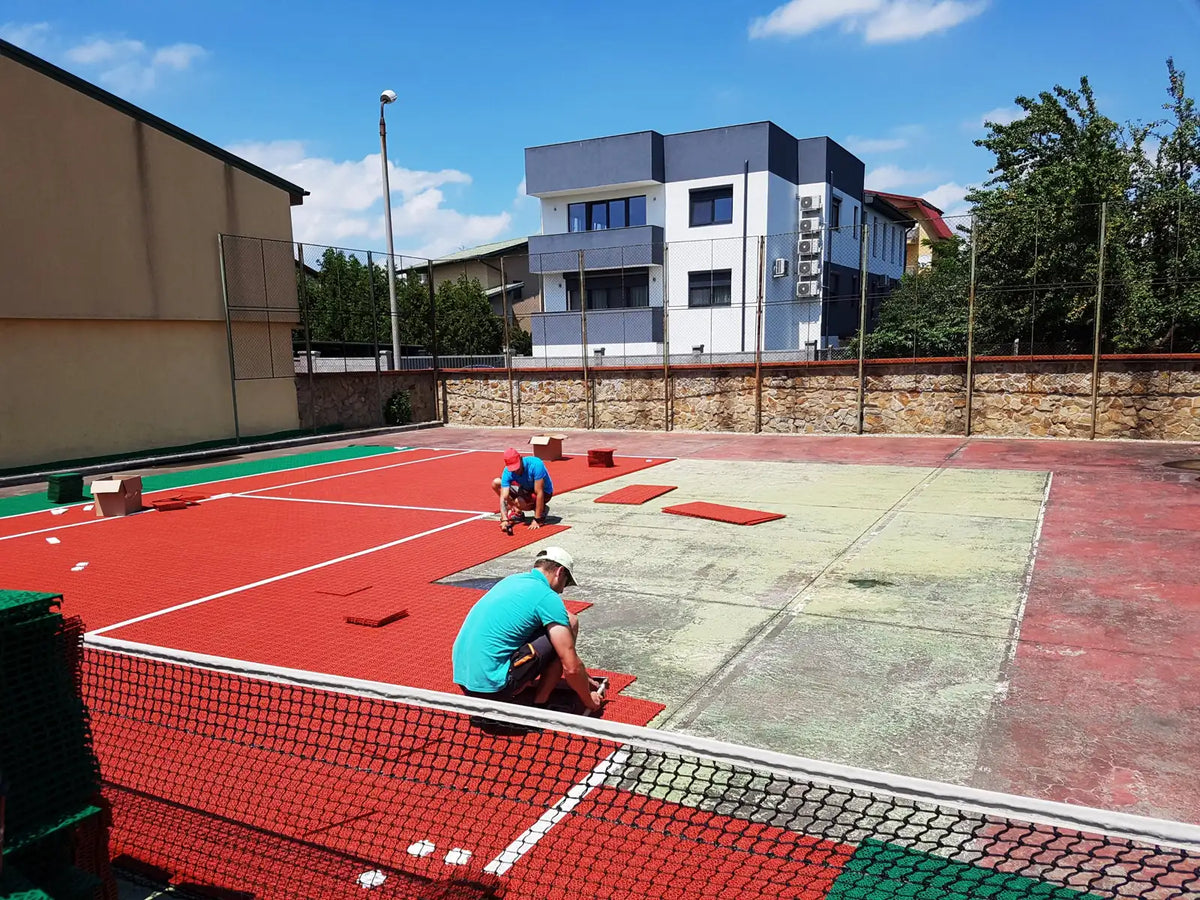 Pose des dalles BERGO ULTIMATE rouges par les poseurs MOSAIK-FLOOR sur l'ancien court de tennis