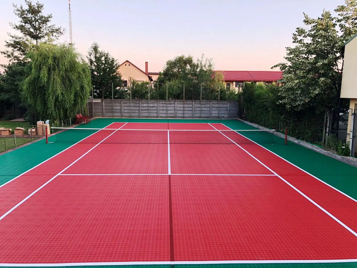 Court de tennis terminé en dalles BERGO ULTIMATE rouge et vert, vue depuis le fond du terrain